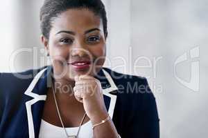 If opportunity doesnt knock, build a door. Portrait of a smiling young businesswoman sitting in an office.