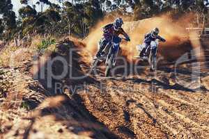 Time to rip up this track. Shot of two motocross racers in action.