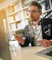 Taking his acumen online. Shot of a businessman making a podcast on his computer.