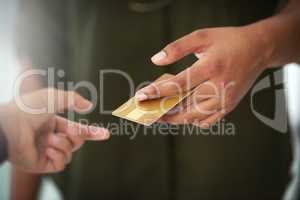 Theres no need to carry cash anymore. Cropped shot of an unrecognisable person handing over a credit card for payment.