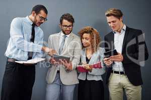 Whats that. Cropped shot of a group of businesspeople using digital tablets and notebooks while waiting in line for a job interview.