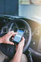 Risky business. Shot of a man using his mobile phone while driving.