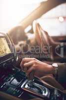 Drive towards your ambitions. Shot of an unidentifiable businesswoman changing the gears while driving a car.