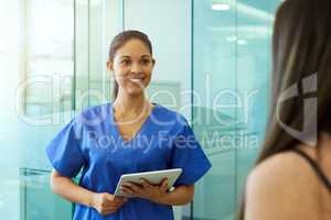 Greeting her patient with a friendly face. Shot of a friendly young nurse greeting a patient in the clinic.