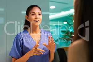 Explaining the ins and outs of medical cover. Shot of a young nurse discussing a procedure with her patient in the clinic.