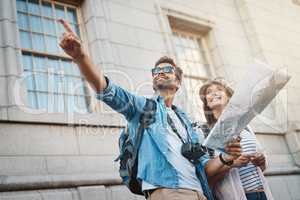 We have nothing to lose and the world to see. Shot of a happy couple using a map while exploring a foreign city.