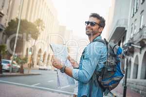 Experience the natural, cultural and man-made wonders of the world. Shot of a young man looking at a map while touring a foreign city.