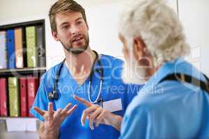 Walking him through the treatment plan. Shot of a young doctor discussing his diagnosis with his senior patient in the hospital.