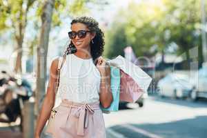 Adding items to my closet. Shot of an attractive young woman going shopping in the city.