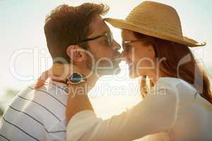 Giving new meaning to the word sunkissed. Shot of a young man kissing his girlfriends nose on a summers day outdoors.