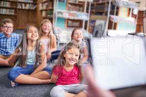 Theyre eager for knowledge. Shot of a group of young children having a lesson at school.