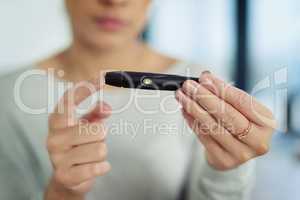 Managing a stable blood-sugar level. Closeup shot of an unidentifiable woman testing her sugar level.