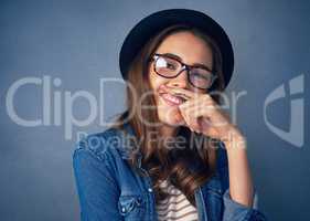 Ive got a finger full of fun. Shot of a comical young woman posing with a mustache drawn on her finger in studio.