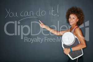 You can have whatever you work for. Shot of a woman holding a scale against a chalk background with a motivational message.
