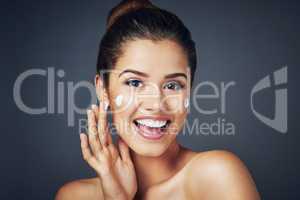 There is no substitute for just looking after your skin. Studio shot of a beautiful young woman with moisturizer on her face while posing against a blue background.