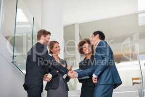 Merging their talents to form the ultimate team. Cropped shot of businesspeople shaking hands in a modern office.