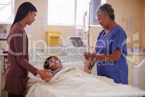 Promise you wont leave my side.... Shot of a patient lying in bed while her visitor and nurse comforts her.