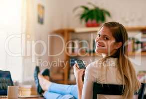 I cant imagine my life without wifi. Portrait of a young woman using her smartphone while sitting at her desk at home.