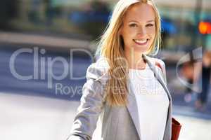 City life suits her. A beautiful woman walking in the city during the day.