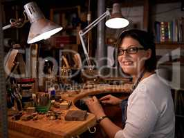 Where I go to de-stress. Shot of a happy young woman sitting at a workbench.