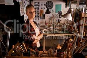Organized chaos. Shot of a beautiful young woman sitting in a workshop.
