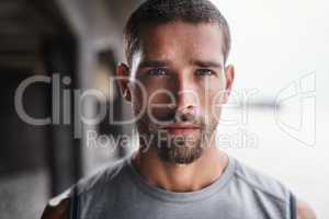 Hes not playing ant games about his fitness. Portrait of a handsome young sportsman looking serious while exercising outdoors.