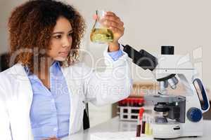 Waiting for the solution to reveal itself. Cropped shot of a young female scientist conducting an experiment in the lab.