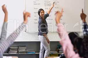 Educating tomorrows leaders. Shot of unidentifiable schoolchildren raising their hands to answer their teachers question in class.