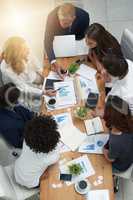 Merging their ideas to create unfailing plans for success. High angle shot of a group of businesspeople having a meeting in an office.