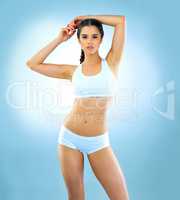 Healthy is the new hot. Studio shot of a beautiful and fit young woman wearing sports wear against a blue background.