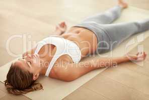 Breathe in... breathe out.... Shot of a sporty young woman doing a relaxation exercise.