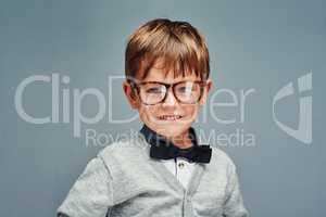 Big style for a little boy. Studio portrait of an adorable little boy dressed smartly against a gray background.