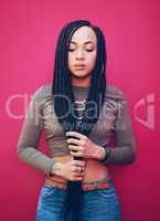 Be true to who you are. Shot of an attractive young woman with braids posing against a pink background.