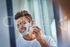 Not today beard. Shot of a handsome young man shaving his facial hair in the bathroom.