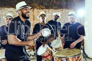 Feeling the rhythm in the drums. Shot of a group of musical performers playing together indoors.