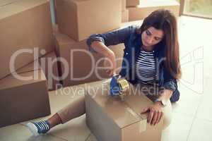 Sealing the last of her belongings. Shot of a young woman packing boxes while moving house.