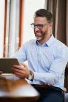 Making his home a place of business. Shot of a mature businessman using a digital tablet to work from home.