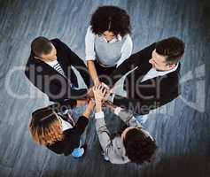 Teamwork allows for the impossible to take place. High angle shot of a group of businesspeople joining their hands together in a huddle.