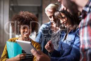 3-D images bring our plans to life. A group of colleagues standing around a digital tablet to assess designs.