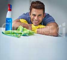 Handsome and tidy, the perfect man. Shot of a young man doing household chores.