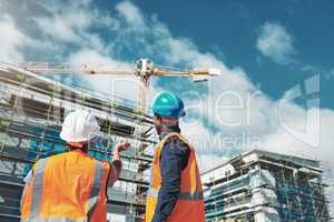 Their reputation is about to raise the roof. Shot of a young man and woman assessing progress of the building at a construction site.