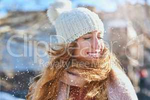 The amazing feeling of snow on your face. Shot of an attractive young woman enjoying being out in the snow.