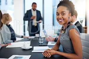 These presentations are always informative. Portrait of a young businesswoman working in the boardroom with her colleagues in the background.
