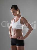 She takes the work out of workout. Shot of an athletic woman standing with her hands on her hips during a workout session.