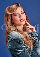 80s fashion trends are back. Cropped shot of a beautiful young woman styled in 80s clothing against a blue background.