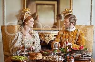 Its an ample feast. Shot of a noble couple eating together.