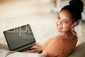 I wonder what social media has in store for me. Shot of a beautiful young woman using a laptop at home.