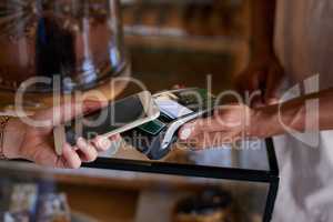 Gone are the days of carrying cash on you. Closeup shot of a customer paying using NFC technology in cafe.