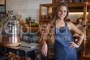 Proud to own one of the best cafes around. Portrait of a young business owner standing in her bakery.