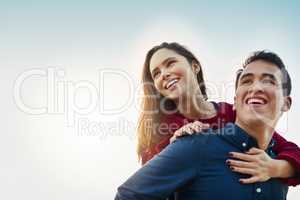 Love brightens up any day. Shot of a happy young couple enjoying a piggyback ride outdoors.